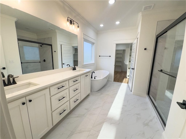 bathroom with a soaking tub, marble finish floor, a stall shower, and a sink