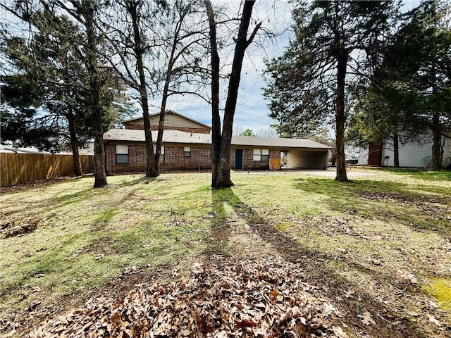 view of yard with an attached carport and fence