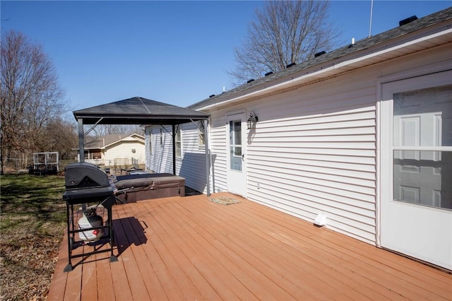 wooden deck featuring a gazebo, a covered hot tub, and area for grilling