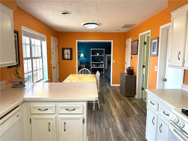 kitchen with visible vents, white appliances, light countertops, and a peninsula