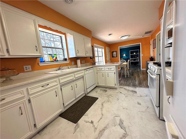 kitchen featuring white appliances, visible vents, a sink, light countertops, and marble finish floor