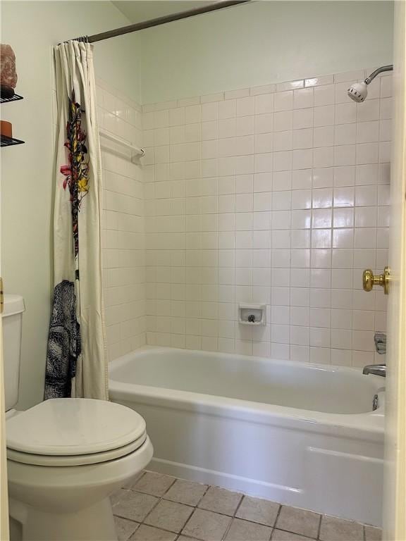 bathroom with toilet, shower / tub combo, and tile patterned flooring