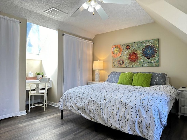 bedroom with wood finished floors, visible vents, lofted ceiling, ceiling fan, and a textured ceiling