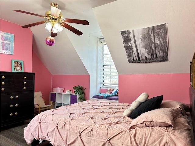 bedroom with a ceiling fan, vaulted ceiling, and wood finished floors