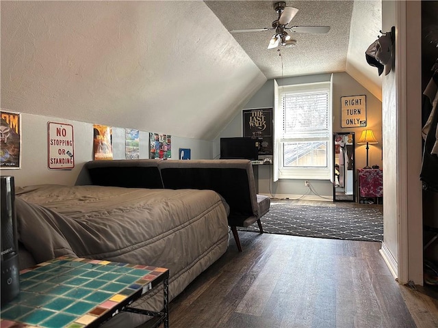 bedroom featuring vaulted ceiling, a textured ceiling, a ceiling fan, and wood finished floors