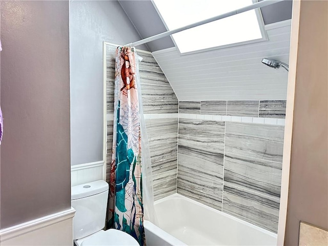 full bathroom featuring toilet, shower / bath combo, wainscoting, and vaulted ceiling