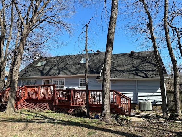 rear view of house with a deck, central AC, and a shingled roof