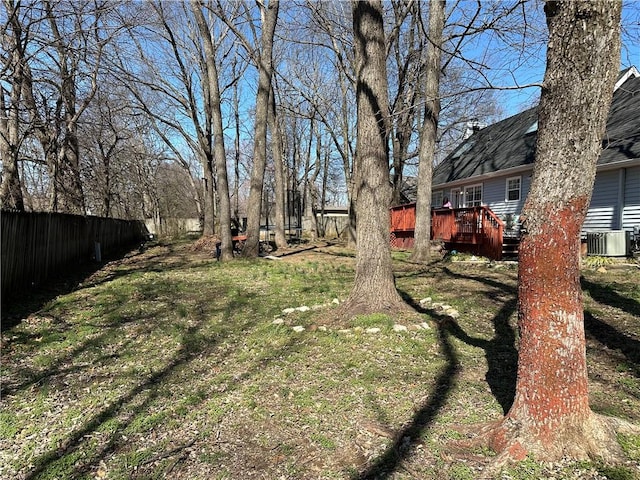 view of yard with a deck, cooling unit, and fence