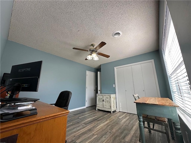 office featuring a textured ceiling, dark wood-type flooring, visible vents, and ceiling fan