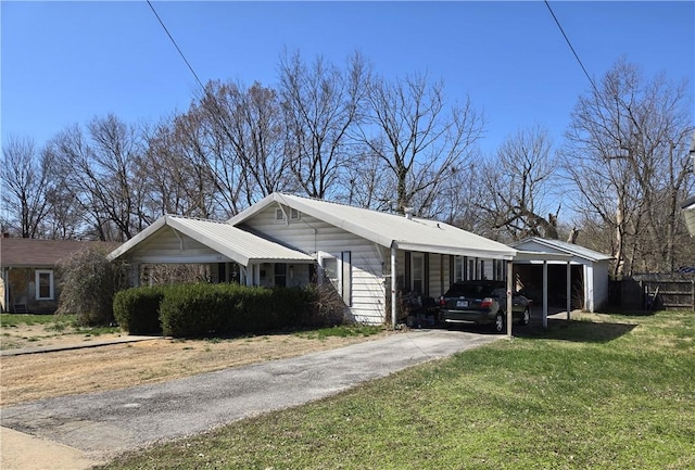 view of side of home with a carport, a lawn, and driveway