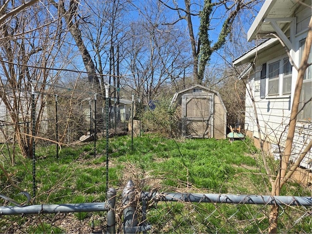 view of yard featuring fence, an outbuilding, and a shed