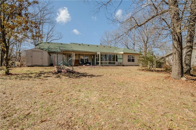 rear view of house with an outbuilding, a sunroom, a yard, and a shed