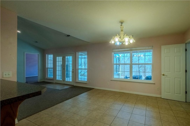 interior space featuring baseboards, lofted ceiling, a notable chandelier, and visible vents