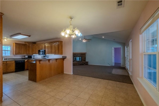 kitchen with black appliances, brown cabinetry, open floor plan, and a peninsula