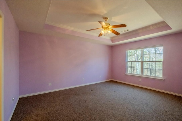 carpeted spare room featuring visible vents, baseboards, and a tray ceiling