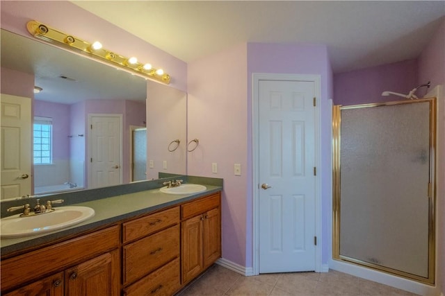 full bathroom with a shower stall, double vanity, tile patterned floors, and a sink