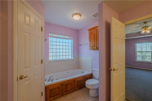 bathroom with a tub with jets, visible vents, ceiling fan, tile patterned flooring, and toilet