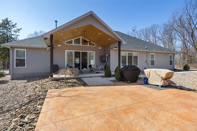 back of property with a shingled roof, a patio, and ceiling fan