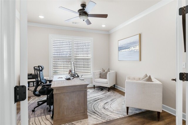 office with visible vents, crown molding, baseboards, wood finished floors, and a ceiling fan