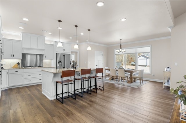 kitchen featuring decorative backsplash, dark wood-type flooring, high end fridge, and a kitchen island with sink