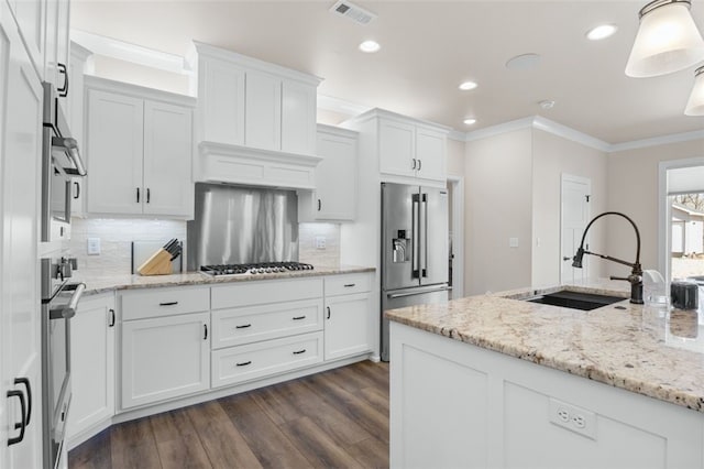 kitchen with white cabinetry, crown molding, appliances with stainless steel finishes, and a sink