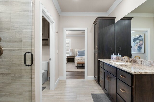 ensuite bathroom featuring toilet, a stall shower, crown molding, baseboards, and vanity