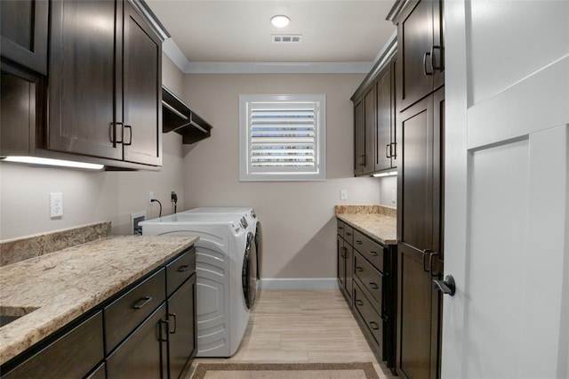 laundry room with visible vents, ornamental molding, washer and clothes dryer, cabinet space, and baseboards