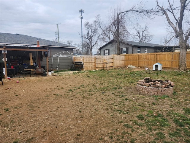 view of yard featuring fence and an outdoor fire pit