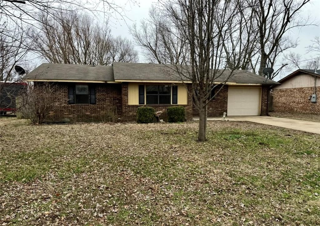 single story home featuring brick siding, concrete driveway, and a garage