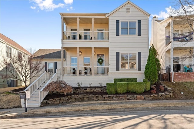 view of front of property featuring brick siding, central AC unit, a porch, and a balcony