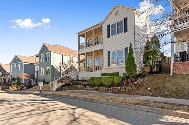 view of front of home with brick siding, a residential view, and a balcony