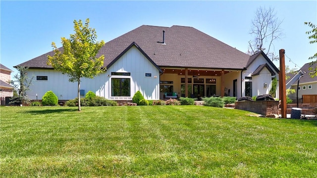 rear view of property featuring a lawn and a ceiling fan