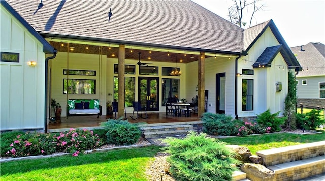 back of property featuring a yard, board and batten siding, and roof with shingles