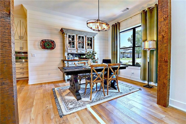 dining area with visible vents, baseboards, and light wood-style flooring