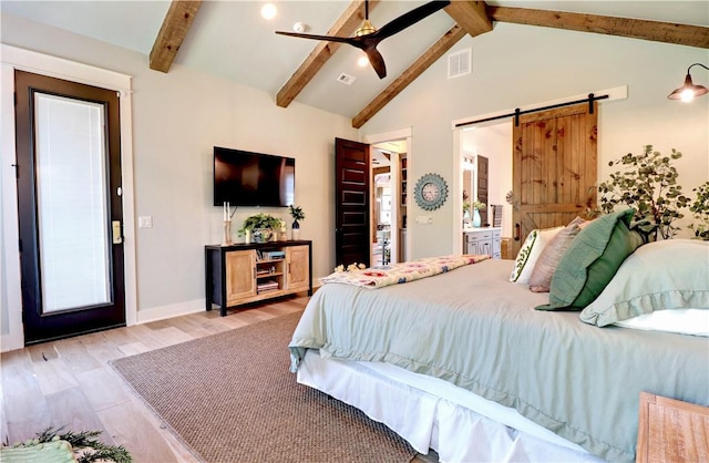 bedroom with light wood finished floors, visible vents, lofted ceiling with beams, and a barn door