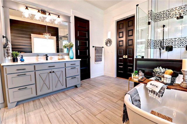 full bath featuring vanity, a soaking tub, and wood tiled floor