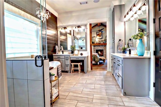 bathroom featuring visible vents, a fireplace, vanity, and log walls