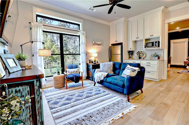 living area with visible vents, ceiling fan, and light wood-style floors