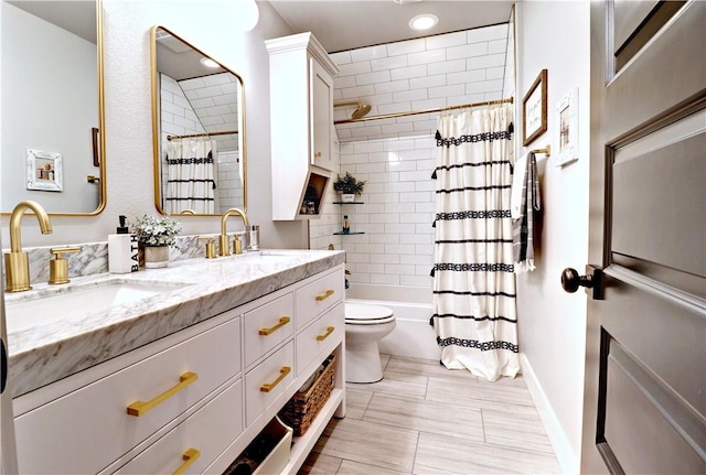 full bathroom featuring double vanity, toilet, shower / bath combo with shower curtain, and a sink