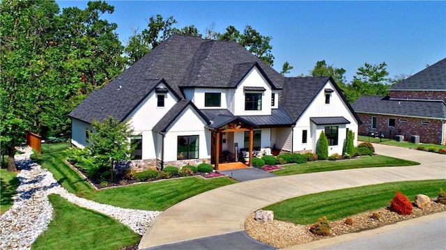 view of front of home featuring a front yard, roof with shingles, a standing seam roof, and metal roof