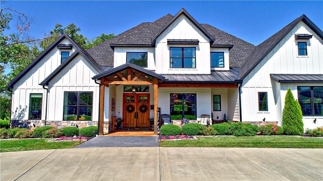 modern farmhouse style home featuring board and batten siding, metal roof, a standing seam roof, and roof with shingles