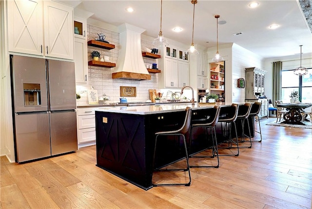 kitchen featuring open shelves, white cabinetry, stainless steel fridge with ice dispenser, and light wood finished floors