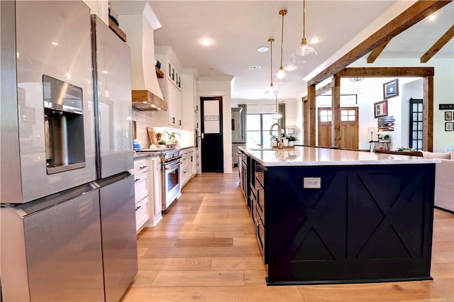 kitchen featuring backsplash, appliances with stainless steel finishes, light wood-style floors, white cabinets, and a sink