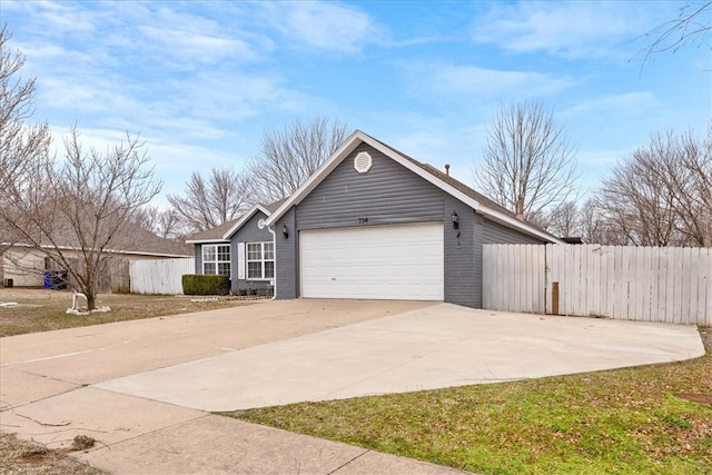 view of side of property featuring a garage, fence, brick siding, and driveway