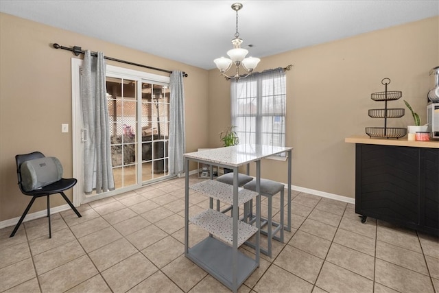 dining room featuring light tile patterned floors, baseboards, and a notable chandelier