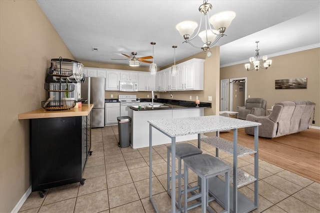 kitchen featuring crown molding, ceiling fan with notable chandelier, light tile patterned flooring, white appliances, and a sink