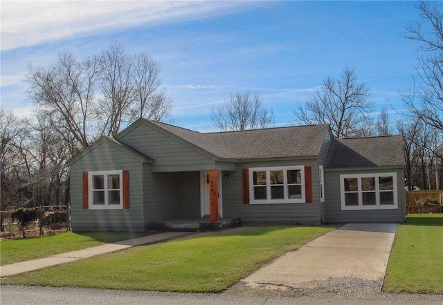 single story home with a shingled roof and a front yard