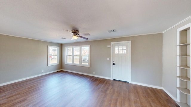 interior space featuring ornamental molding, baseboards, and wood finished floors