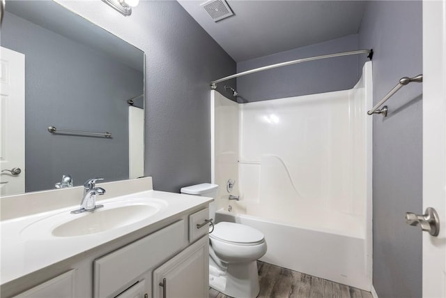 bathroom with visible vents, toilet, wood finished floors, washtub / shower combination, and vanity