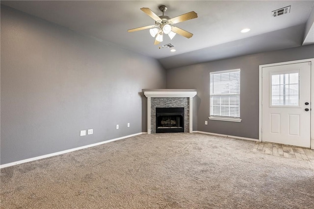 unfurnished living room with carpet, baseboards, visible vents, a fireplace, and vaulted ceiling